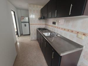 een keuken met een wastafel en een fornuis bij Hermoso apartamento al norte de Armenia in Armenia