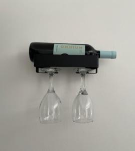 a wine bottle and two wine glasses hanging from a rack at Studios Montevideo in Buenos Aires