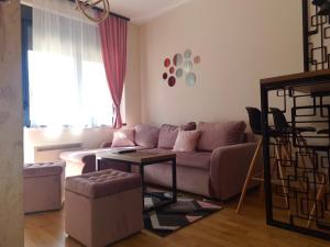 a living room with a couch and a table at Apartman M2 Titova Vila in Palisat