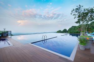 达兰萨拉Radisson Blu Resort Dharamshala的享有水景的甲板上的游泳池