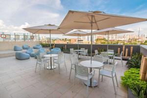 a patio with tables and chairs and umbrellas at Sonesta Hotel Bucaramanga in Bucaramanga