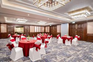 a banquet hall with red and white tables and chairs at Radisson Blu Resort Dharamshala in Dharamshala