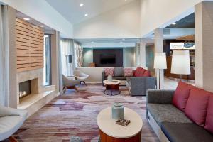 a hotel lobby with couches and a fireplace at Sonesta Select Raleigh Durham Airport Morrisville in Morrisville
