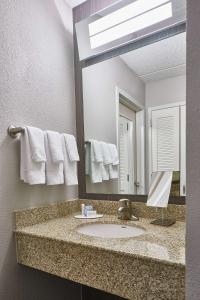 a bathroom with a sink and a mirror at Sonesta Select Raleigh Durham Airport Morrisville in Morrisville