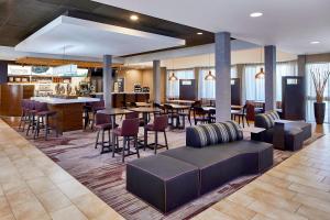 a lobby of a hotel with tables and chairs at Sonesta Select Raleigh Durham Airport Morrisville in Morrisville