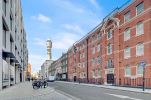 a city street with buildings and a tower in the background at SERCASA - Cleveland Residence - Fitzrovia in London