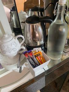 a counter with a tea pot and a bottle on it at Rode house home stay in Rode Heath