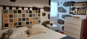 ein Schlafzimmer mit einem Bett und einer Wand mit Steinen in der Unterkunft Casa da Vitória in Santa Cruz da Graciosa