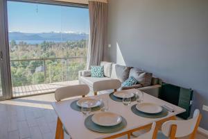 een woonkamer met een tafel en een groot raam bij V&P Apt in Bariloche