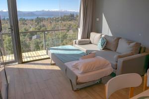 uma sala de estar com um sofá e uma varanda em V&P Apt em San Carlos de Bariloche