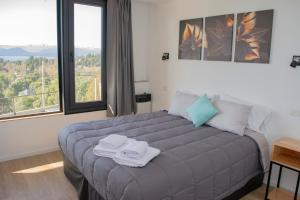 1 dormitorio con 1 cama grande y toallas. en V&P Apt en San Carlos de Bariloche