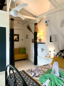 a bedroom with a bed and a couch at LODGE PAMPLEMOUSSE avec PISCINE privative , dans parc calme à 500 m plage in Le Carbet