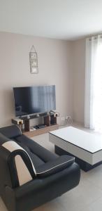 a living room with a couch and a table at Le Paradis des Fleurs in Le Tréport