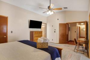 a bedroom with a bed and a flat screen tv at Family Friendly Pool Paradise Retreat Near Beaches in Palm Harbor +25 photos