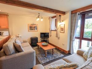 a living room with two couches and a table at Gowan Cottage in Staveley