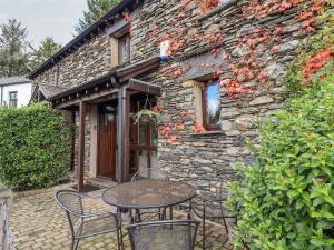 a table and chairs in front of a stone building at Gowan Cottage in Staveley