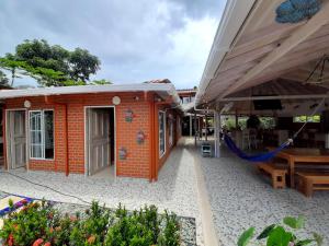 un pequeño edificio de ladrillo rojo con patio en Hostal Bralgijon Capurganá, en Capurganá