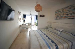 a bedroom with a large bed and a television at Sailor Lovers - Jacuzzi Fuerteventura in Gran Tarajal