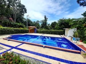a swimming pool with blue tiles on a patio at Hostal Bralgijon Capurganá in Capurganá