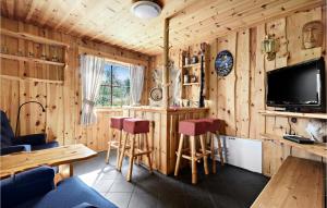 een woonkamer met een tv en houten wanden bij Stunning Home In Norheimsund With House A Mountain View in Norheimsund