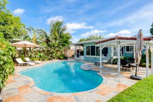 a swimming pool with a patio and a house at Casa Contenta in Fort Lauderdale