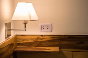 a lamp and a lightswitch and a clock on a wall at Hotel Cuatro Pinos in Oberá