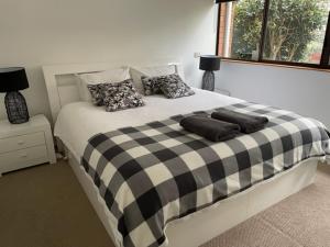 Un dormitorio con una cama grande con almohadas. en Jervis Bay Beachfront, en Vincentia