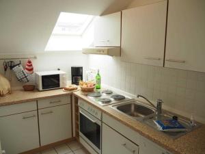eine Küche mit Spüle und Mikrowelle in der Unterkunft Residenz Villa Eintracht in Göhren