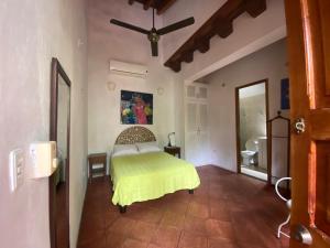 a bedroom with a bed with a yellow bedspread at Casa Digna in Cartagena de Indias