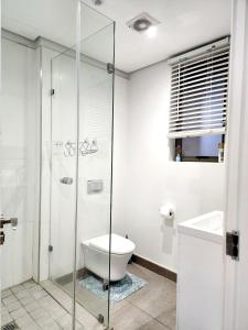 a bathroom with a toilet and a glass shower at Sugar Shores - Studio Apartment in Sibaya