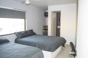 1 dormitorio con 2 camas y ventana en APARTAMENTOS AMBASSADOR, en Tijuana