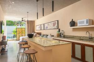 a kitchen with a counter and bar with stools at Studio Amazing for 4 Casa Azul in Tulum
