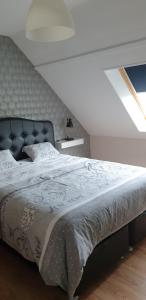 a bedroom with a large bed with a black headboard at Le Paradis des Fleurs in Le Tréport
