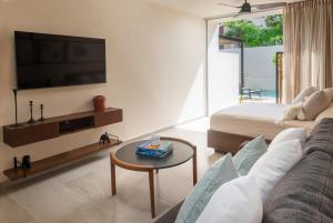 a living room with a couch and a tv at Studio Amazing for 4 Casa Azul in Tulum