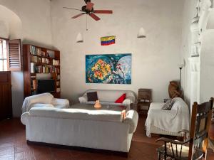a living room with a couch and a ceiling fan at Casa Digna in Cartagena de Indias