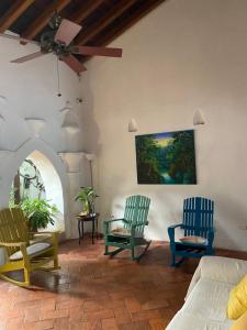 a living room with two chairs and a ceiling fan at Casa Digna in Cartagena de Indias