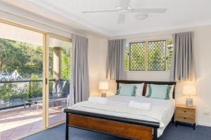 a bedroom with a bed and a balcony at 4/84 Lawson Street - Beach Haven 4 in Byron Bay