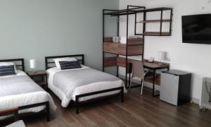 1 dormitorio con 2 camas, escritorio y estante en NEREO rooms, en Lima