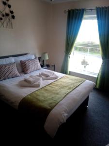 a bedroom with a large bed with blue curtains and a window at Fox and Hounds Apartment in Willingham