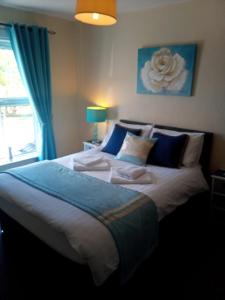 a bedroom with a large bed with blue pillows at Fox and Hounds Apartment in Willingham