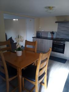 uma cozinha com uma mesa de jantar em madeira e cadeiras em Fox and Hounds Apartment em Willingham