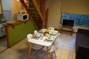 a dining room with a white table and white chairs at La Barranca in Ushuaia