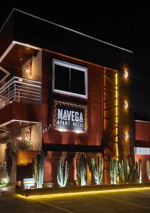 a building with a sign on the side of it at Navega Apart Hotel in Navegantes