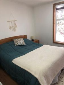Schlafzimmer mit einem Bett und einem Fenster in der Unterkunft Departamentos Carrera Nro 1 in Punta Arenas