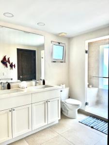 a bathroom with two sinks and a toilet and a shower at Condo at Krystal Grand Resort in Bucerías