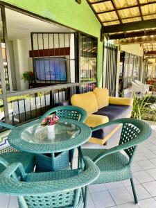 a patio with a table and chairs and a couch at casa praia beira mar praia Flamengo in Salvador