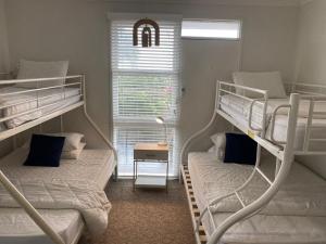 two bunk beds in a room with a window at Beach House On Golf in Mollymook