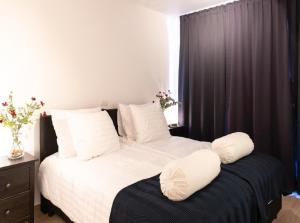 a bedroom with a bed with white sheets and pillows at OneLuxStay near Diamond District in Antwerp