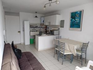 Minidepartamento en San Bartolo - VISTA AL MAR في سان بارتولو: غرفة معيشة مع طاولة وكراسي ومطبخ