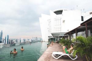 a pool on the roof of a building with people in it at La Vista @ Regalia Residence in Kuala Lumpur